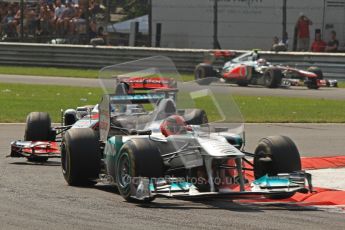 © Octane Photographic Ltd. 2011. Formula 1 World Championship – Italy – Monza – 11th September 2011 Michael Schumacher bounces his Mercedes onto 3 wheels under pressure from Lewis Hamilton's McLaren – Race – Digital Ref : 0177CB7D8081