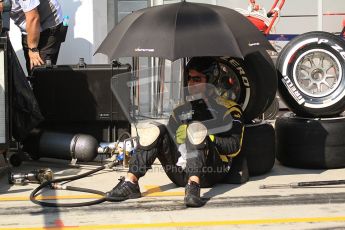© 2012 Octane Photographic Ltd. Hungarian GP Hungaroring - Saturday 28th July 2012 - Lotus GP mechanic sheltering from the blistering sun. Digital Ref : 0431cb7d0701