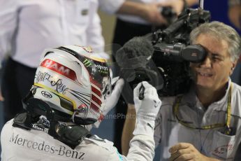 World © Octane Photographic Ltd. Sunday 23rd November 2014. Abu Dhabi Grand Prix - Yas Marina Circuit - Formula 1 Podium. Mercedes AMG Petronas – Lewis Hamilton - Race winner and 2014 World Champion signing the TV camera lens. Digital Ref: 1173CB1D0625