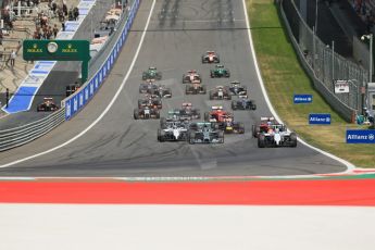 World © Octane Photographic Ltd. Sunday 22nd June 2014. Red Bull Ring, Spielberg - Austria - Formula 1 Race. The Williams Martini Racing FW36 of Felipe Massa leads the pack away on the opening lap as Rosberg's Mercedes dives past Bottas. Digital Ref: 1000LB1D5019