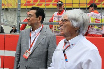 World © Octane Photographic Ltd. Honda chief executive Takahiro Hachigo and Bernie Ecclestone. Sunday 21st June 2015, F1 Austrian GP Grid, Red Bull Ring, Spielberg, Austria. Digital Ref: 1318LW1L4003