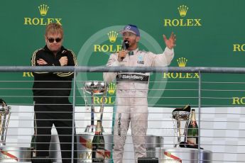 World © Octane Photographic Ltd. Mercedes AMG Petronas F1 W06 Hybrid – Lewis Hamilton being interviewed by Sir Elton John. Sunday 25th October 2015, F1 USA Grand Prix Race - Podium, Austin, Texas - Circuit of the Americas (COTA). Digital Ref: 1467LB1D3058