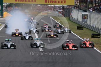 World © Octane Photographic Ltd. Off the line with the Scuderia Ferrari SF15-Ts of Sebastian Vettel and Kimi Raikkonen getting the jump on Mercedes. Sunday 26th July 2015, F1 Hungarian GP Race, Hungaroring, Hungary. Digital Ref: 1360LB1D2445