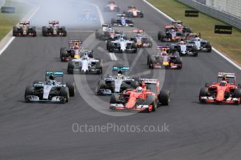 World © Octane Photographic Ltd. The pack enters turn 1 with the Scuderia Ferrari SF15-T of Sebastian Vettel in the lead. Sunday 26th July 2015, F1 Hungarian GP Race, Hungaroring, Hungary. Digital Ref: 1360LB1D2456