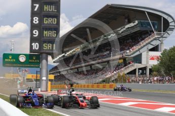 World © Octane Photographic Ltd. Formula 1 - Spanish Grand Prix Race. Carlos Sainz - Scuderia Toro Rosso STR12 and Kevin Magnussen - Haas F1 Team VF-17 go wheel to wheel out of the pits. Circuit de Barcelona - Catalunya, Spain. Sunday 14th May 2017. Digital Ref:1825LB1D4353