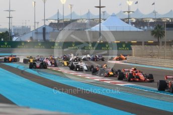 World © Octane Photographic Ltd. Formula 1 –  Abu Dhabi GP - Race. McLaren MCL33 – Fernando Alonso and Haas F1 Team VF-18 – Romain Grosjean run wide on the first corner. Yas Marina Circuit, Abu Dhabi. Sunday 25th November 2018.