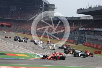 World © Octane Photographic Ltd. Formula 1 – German GP - Race. Lap 1 Turn 1, Scuderia Ferrari SF71-H – Sebastian Vettel leads Mercedes AMG Petronas Motorsport AMG F1 W09 EQ Power+ - Valtteri Bottas and team mate Kimi Raikkonen. Hockenheimring, Baden-Wurttemberg, Germany. Sunday 22nd July 2018.