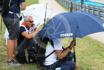 World © Octane Photographic Ltd. Formula 1 – Hungarian GP - Practice 2. RTL video/commentary team sheltering under umbrellas. Hungaroring, Budapest, Hungary. Friday 2nd August 2019.