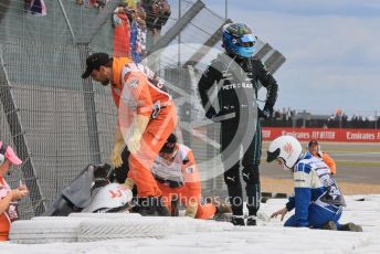 World © Octane Photographic Ltd. Formula 1 – British Grand Prix - Silverstone. Sunday 3rd July 2022. Race. Alfa Romeo F1 Team Orlen C42 - Guanyu Zhou's car wedged behind the barrier with him still in it as Mercedes-AMG Petronas F1 Team F1 W13 - George Russell watches the extraction.
